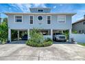 Stilt home with large driveway and parking, complemented by lush landscaping at 13974 75Th Ave, Seminole, FL 33776