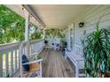 Relaxing outdoor porch with rocking chairs, bench seating, and views of the outdoors at 13974 75Th Ave, Seminole, FL 33776