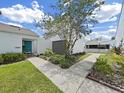 Villa with walkway that leads to a vibrant turquoise front door and green landscaping at 14205 Cypress Ter, Tampa, FL 33618
