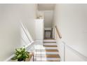 Bright stairway with white risers, wooden treads, and white walls with picture-frame molding at 1476 Harbour Walk Rd, Tampa, FL 33602