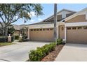 Home's two-car garage with decorative windows, landscaping, and driveway leading to street at 19129 Lake Audubon Dr, Tampa, FL 33647