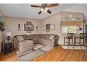 Comfortable living room featuring a large sectional sofa, wood-look flooring, and a ceiling fan at 2153 Catalina N Dr, Clearwater, FL 33763