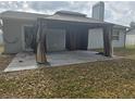Covered backyard patio area with neutral tones and possible entrance to the house at 23015 Mayfair Rd, Land O Lakes, FL 34639