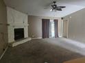 Cozy living room features a stone fireplace, ceiling fan, and sliding glass doors at 23015 Mayfair Rd, Land O Lakes, FL 34639