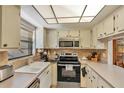 Functional kitchen features a stainless steel range, updated cabinets, and a convenient breakfast bar at 2400 Winding Creek Blvd # 24-102, Clearwater, FL 33761