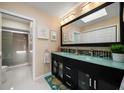 A luxurious bathroom featuring a double vanity with modern fixtures, a large mirror, and a walk-in shower at 2511 Bay Blvd # B, Indian Rocks Beach, FL 33785