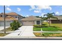 Charming single-Gathering home with a well-maintained lawn, concrete driveway, and a two-car garage at 25830 Crippen Dr, Land O Lakes, FL 34639
