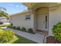 Inviting front entrance with a covered porch, neutral-colored door, and manicured landscaping at 25830 Crippen Dr, Land O Lakes, FL 34639