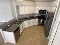 Well-lit kitchen features granite countertops, stainless steel appliances, and white cabinets at 25830 Crippen Dr, Land O Lakes, FL 34639