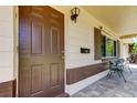 Inviting front entrance featuring a classic brown door, brick accents, and a cozy seating area at 2800 54Th N St, St Petersburg, FL 33710