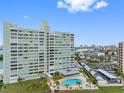 Exterior view of the condo building, showcasing the pool, green space, and covered parking at 31 Island Way # 1507, Clearwater Beach, FL 33767
