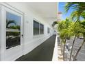 Exterior building hallway showing unit 206, dark gray flooring, white railings and walls, and mature palm trees at 3128 59Th S St # 206, Gulfport, FL 33707