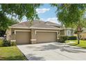Spacious three-car garage with a long driveway, offering plenty of parking and storage at 4511 Swift Cir, Valrico, FL 33596