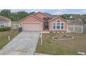 Inviting single-story home with a manicured lawn, attached garage, and decorative white picket fencing at 4617 Horseshoe Pick Ln, Valrico, FL 33594