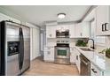 Modern kitchen with stainless steel appliances, white cabinets, and stone countertops at 4940 Rosedale Ln, Holiday, FL 34690