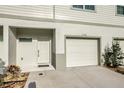 The exterior of a townhouse featuring a garage, entry door, and decorative plants at 6306 Tillandsia Pl, Tampa, FL 33610