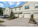Charming townhouse with an attached garage, driveway, and manicured landscaping at 6306 Tillandsia Pl, Tampa, FL 33610