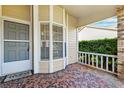 Covered front porch with patterned tile and view of the lawn at 6514 Thicket Trl, New Port Richey, FL 34653