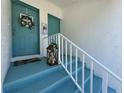 Townhome entrance with blue painted stairs, white railing, wreath and décor at 6534 Fairway Gardens Dr # 17-201, Bradenton, FL 34203