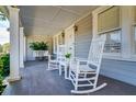 Inviting covered front porch with rocking chairs and hanging planters, perfect for relaxing at 827 S Delaware Ave, Tampa, FL 33606