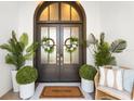 Inviting front entrance with double doors, potted plants, and a charming 'Welcome' mat at 885 Seaview Cir # 20, Crystal Beach, FL 34681