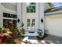 Covered front entrance with white-tiled floor, double front doors, and side-mounted lighting at 9315 Knightsbridge Ct, Tampa, FL 33647