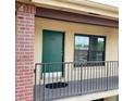 A close-up view of unit 222's entrance with a green door, window, and black railing at 1020 85Th N Ave # 222, St Petersburg, FL 33702
