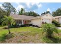 Inviting single-story home boasts lush landscaping, a quaint front porch, and attached garage, creating a warm and welcoming curb appeal at 10516 Mira Vista Dr, Port Richey, FL 34668