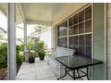 View of a tiled porch with a bench and table, surrounded by lush plantings at 10516 Mira Vista Dr, Port Richey, FL 34668