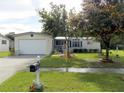 Beautifully landscaped single-story house with an attached garage and a lush green lawn at 11312 Brussels Boy Ln, Riverview, FL 33578