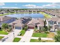 Expansive aerial view of the property with a lake view, solar panels, and a well manicured landscape at 11688 Brighton Knoll Loop, Riverview, FL 33579