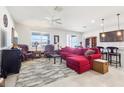 Bright living room with neutral tile flooring, comfortable red sectional, and classic leather armchairs at 11688 Brighton Knoll Loop, Riverview, FL 33579