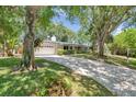 Beautiful single story home with mature trees and a long brick driveway at 1242 Nelson St, Dunedin, FL 34698