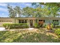 Inviting single story home with a well-maintained lawn and mature landscaping at 1242 Nelson St, Dunedin, FL 34698