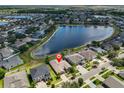 Wide aerial view of the home in a neighborhood with a pond, close to other houses at 13742 Artesa Bell Dr, Riverview, FL 33579