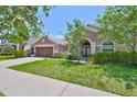 Inviting single-story home with lush green lawn, covered entryway, and attached two-car garage at 13742 Artesa Bell Dr, Riverview, FL 33579