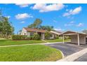 Beautiful single-story home with green lawn and covered carport in a sunny neighborhood at 15 Tads Trl, Oldsmar, FL 34677