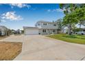 Inviting two-story home with a well-manicured lawn, charming front porch, and a spacious driveway leading to an attached garage at 1501 84Th N Ave, St Petersburg, FL 33702