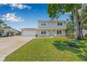 Inviting two-story home with a well-manicured lawn, charming front porch, and a spacious driveway leading to an attached garage at 1501 84Th N Ave, St Petersburg, FL 33702
