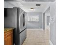 A glimpse of a kitchen with stainless steel refrigerator and light-filled dining area at 2026 Cocoanut Ave, Sarasota, FL 34234