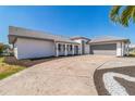 Well-maintained single-story home with a gray roof, neutral paint, and a spacious driveway leading to the garage at 2161 Aqui Esta Dr, Punta Gorda, FL 33950