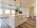 Open-concept kitchen with a large island, white cabinets, modern fixtures, and vinyl flooring at 2161 Aqui Esta Dr, Punta Gorda, FL 33950