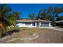 Inviting single-story house with a gray garage door and a quaint front porch at 2167 Corfell St, Port Charlotte, FL 33948