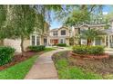 Exterior showcases townhomes with sidewalks, manicured greenery, and mature trees at 2373 Hounds Trl, Palm Harbor, FL 34683