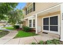 Close exterior view of a townhome, with manicured greenery and a sidewalk at 2373 Hounds Trl, Palm Harbor, FL 34683