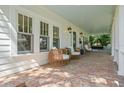 Relaxing front porch features wicker seating and a hanging swing for outdoor enjoyment at 2523 W Sunset Dr, Tampa, FL 33629