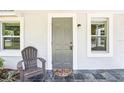 Close-up of the home's entrance, highlighting the stylish gray door and tiled porch at 2604 Oakdale St, Seffner, FL 33584