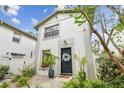 Lovely townhome featuring a black front door, a decorative wreath, and neat landscaping, enhancing curb appeal at 310 S Delaware Ave # F, Tampa, FL 33606