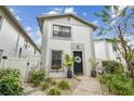 Delightful townhouse boasting a neat garden, black front door and charming curb appeal under a blue sky at 310 S Delaware Ave # F, Tampa, FL 33606