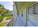 The serene outdoor hallway provides access to apartments, enhanced with picturesque views of palm trees at 330 Promenade Dr # 206, Dunedin, FL 34698